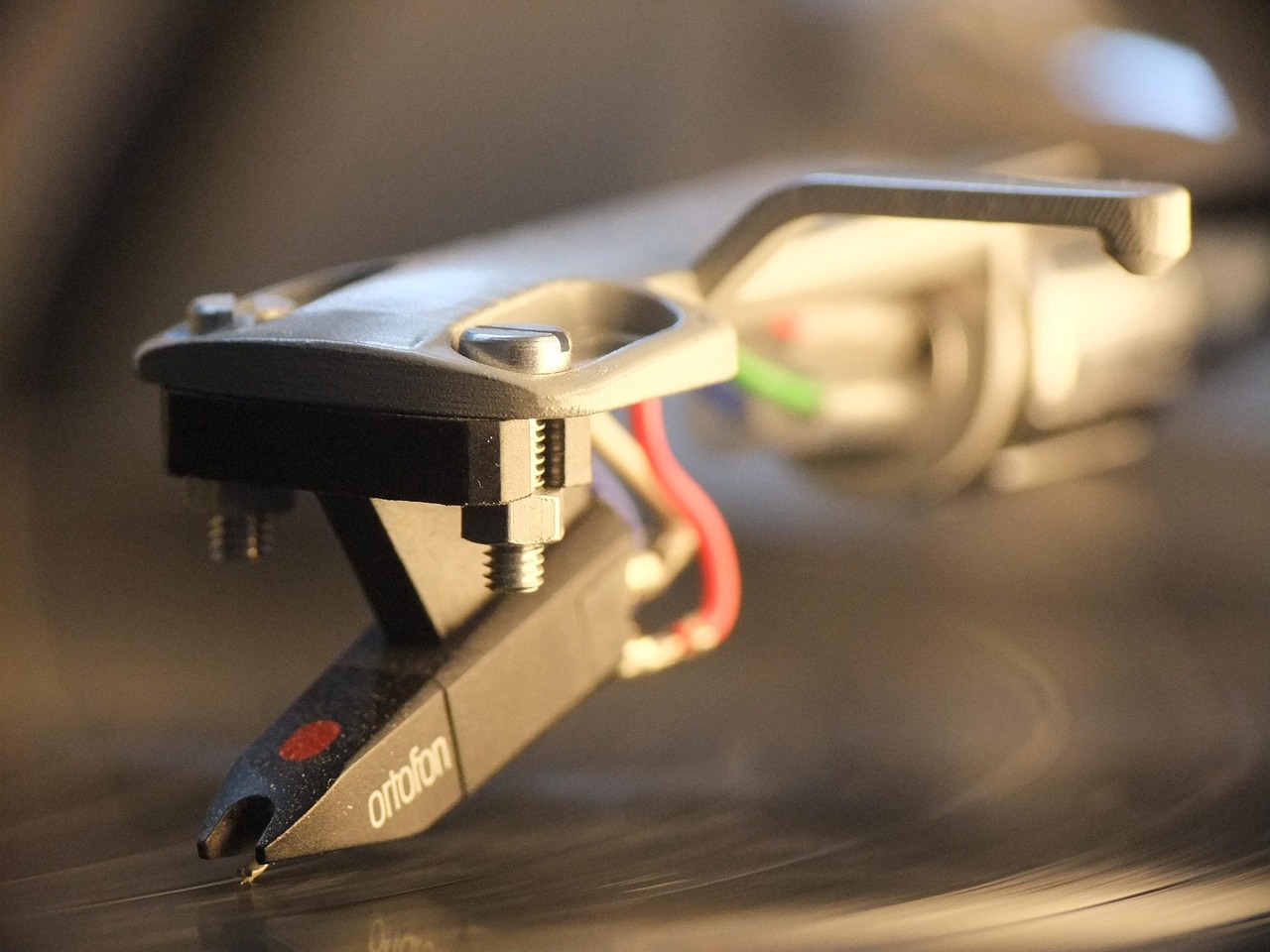 Vinyl record spinning on turntable with tonearm and stylus detail